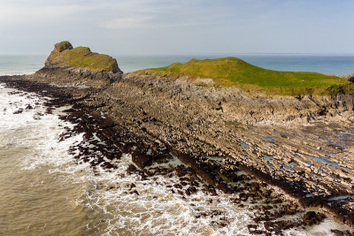退潮时壮观的岩石海岸鸟瞰图(威尔士Worm's Head)