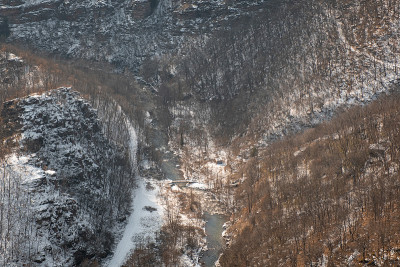 从上面看，被雪覆盖的峡谷和河流被雪覆盖的悬崖和桔子树包围