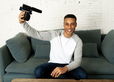 Lifestyle portrait of young happy male blogger on 