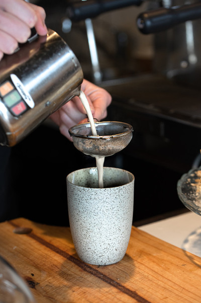 咖啡师为印度茶拿铁倒牛奶