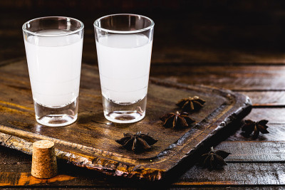 Ouzo或Uzo是一种希腊茴香白兰地，传统的烈性酒精饮料，用玻璃杯盛在旧木桌上。希腊传统，喝神的酒。