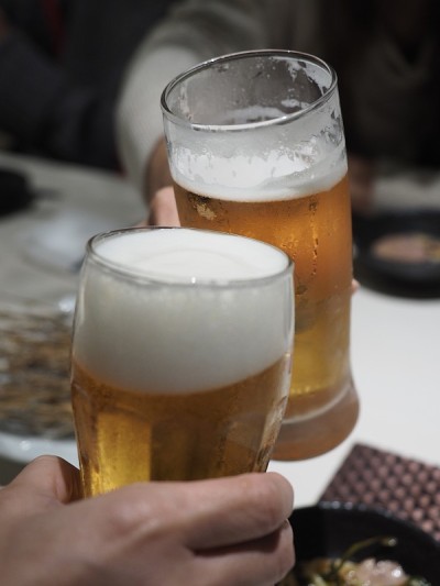 两个人在餐桌上用啤酒杯敬酒