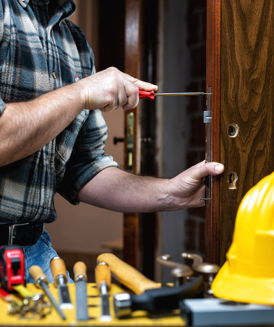 Carpenter at work repairs and installs the door lo