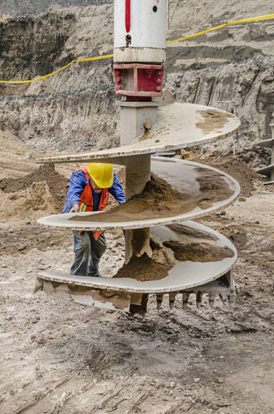 Worker positioning a drilling work tool to bore an
