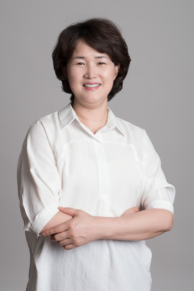 在灰色背景下摆姿势的美丽成熟女人的肖像