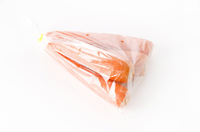 白色背景的塑料袋里的新鲜胡萝卜