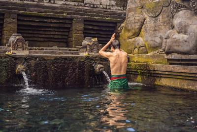 巴厘岛圣泉寺的人。寺庙由一个以其神圣的泉水而闻名的浴场结构组成