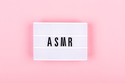 粉红色背景上有ASMR字母的灯。