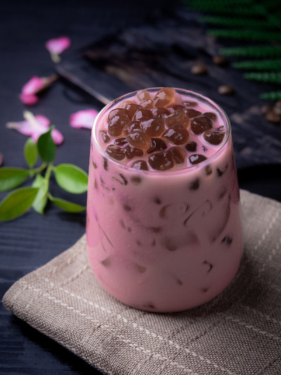 玫瑰奶茶与泡沫(木薯球)在木材背景
