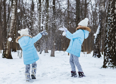 小女孩们，姐妹们在雪地里散步，玩得很开心。时髦的衣服，有毛皮的蓝色夹克，有雪花的暖和的裤子，猫形状的
