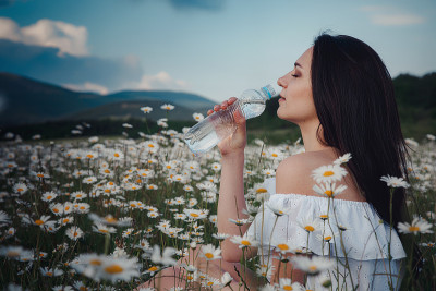 美丽的黑发女人正在雏菊地里享受春天