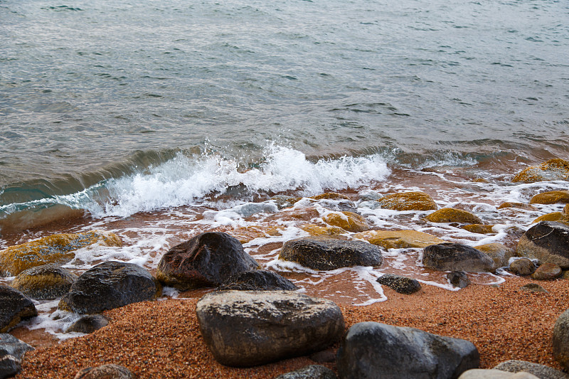 海滩上的石头。牧场的冬日。清澈的水和沙子。吉尔吉斯斯坦、吉湖