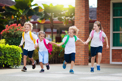 孩子重返学校。暑假后新学年开始。第一天上学的小女孩背着书包和书。类的开始。幼儿园和学龄前儿童的教育。