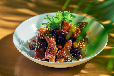 糖醋排骨，香菜，芝麻和花椒放在白碗里。中国菜