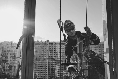 工业登山工人悬挂在住宅外立面建筑上