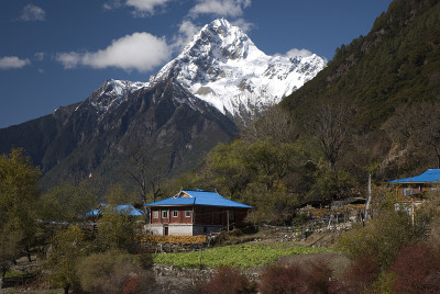 一座藏人的房子坐落在喜马拉雅山峰的阴影里。