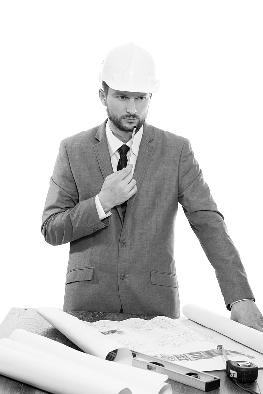 成熟的男性建筑师一边构思蓝图一边思考