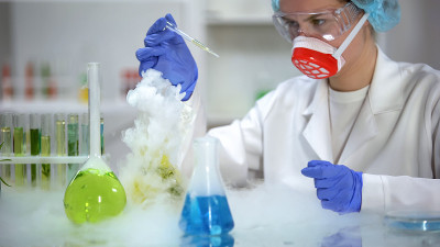 科学家用移液管采集黄色液体样本，检查沉积物、汽油