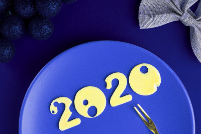 图2020用奶酪做的有孔的蓝色盘子和小叉子在空桌子上装饰圣诞节，俯视图。圣诞节，新年概念餐厅，men