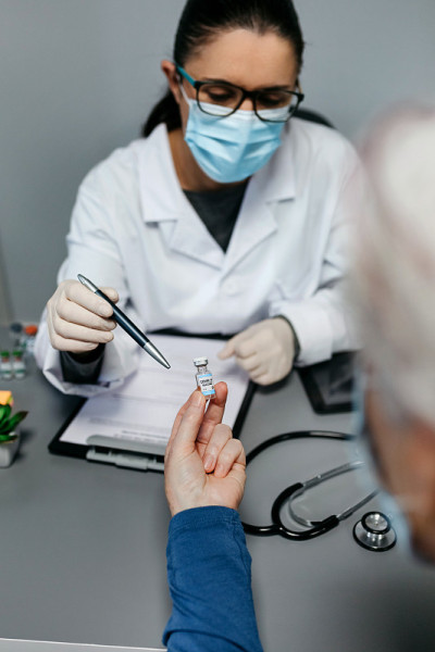 医生向病人解释冠状病毒疫苗的好处和风险