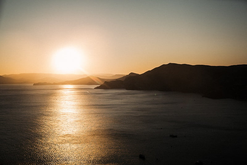 海景。海岸上的日落。晚上的大海。太阳在地平线以下。岩石。美丽的大自然