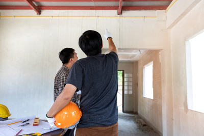 工程师或建筑师在建筑工地与工头讨论项目