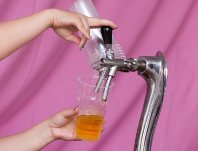 酒保把啤酒倒进塑料玻璃杯