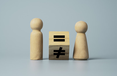 在男人和女人之间翻转不等等号的木雕。人与商业权利的概念。