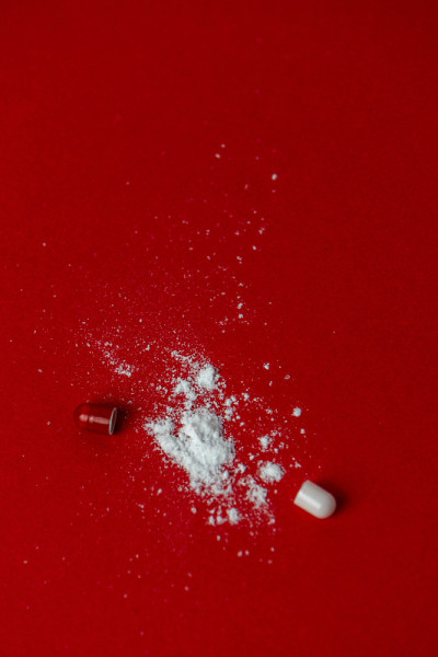 打开的止痛胶囊在红色的背景与副本空间