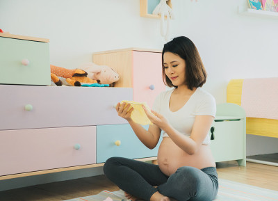 孕妇正在为即将出生的婴儿准备衣服。