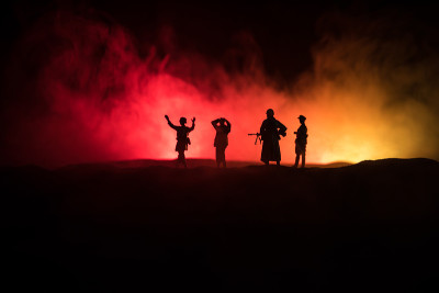 战斗场景。军事剪影战斗场景的战争雾天空背景。士兵们举起武器投降。带枪的塑料玩具士兵俘虏了敌兵。