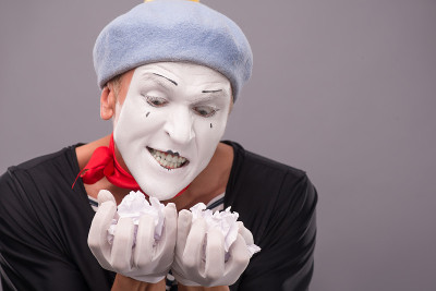 肖像滑稽男性哑剧与灰帽子和白色