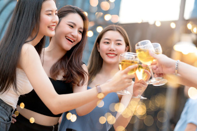 一组美丽迷人的亚洲朋友女性一起庆祝屋顶派对与欢快的饮料舞蹈史密斯节奏的派对音乐与灯光和散科背景