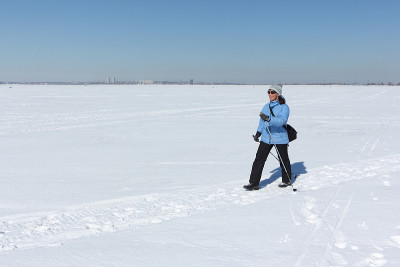 穿着蓝色夹克在雪地上徒步旅行的女人