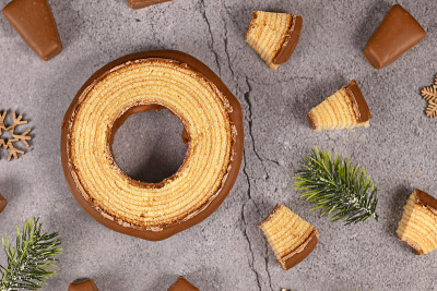 这是德国传统的圆形多层冬季蛋糕，名为“Baumkuchen”，上面涂着巧克力，显示出蛋糕里面薄薄的一