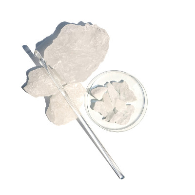明矾晶体在化学手表玻璃旁边的搅拌棒上的白色实验室表。俯视图
