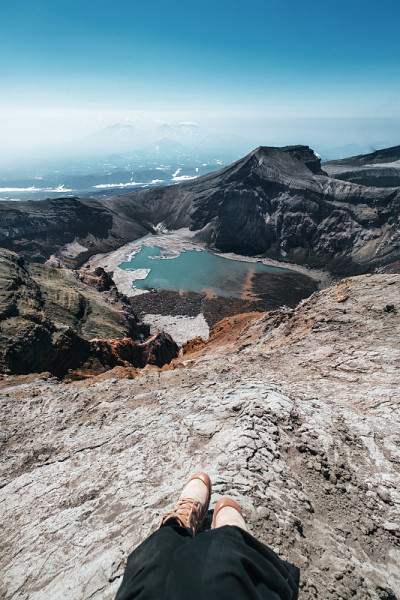 在堪察加戈雷火山的火山口和湖泊之上的山顶上，女人的腿