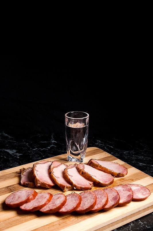 小酒杯里放着伏特加、熏肉片和熏香肠