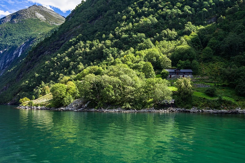 近距离观看在阳光照耀下的Geirangerfjord斜坡上的农场，Sunnmore, More og