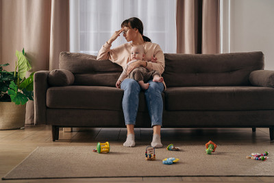 年轻疲惫的妇女患有产后抑郁症在家