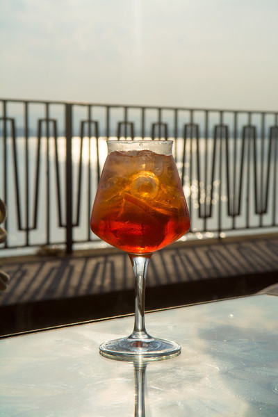 侍者准备了Aperol Sprits夏季鸡尾酒Aperol, prosecco，冰块和橙子在葡萄酒杯