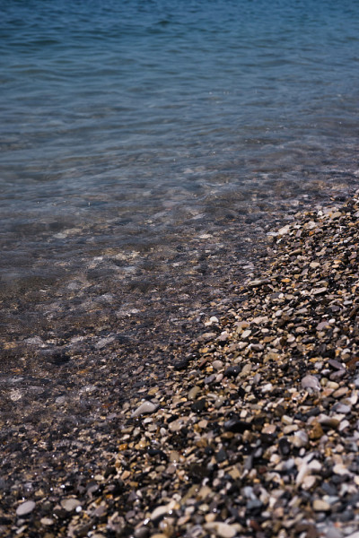一个波浪滚过布满岩石的海岸。卵石滩。海滨。