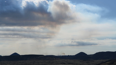 火山在蓝天下喷发。岩浆飞溅。