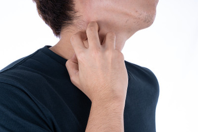 男性在孤立的白色背景上抓挠脖子。医疗、保健为广告概念。