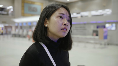 年轻女子在机场看航班信息显示。