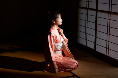 穿着和服的年轻女子坐在榻榻米垫子上