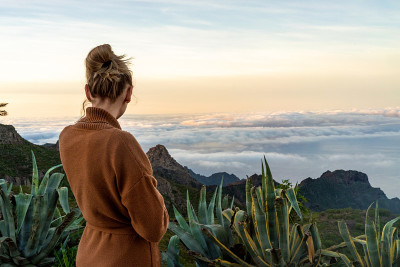 宁静的女人看着美丽的风景在山上。