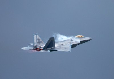 F-22猛禽在高G机动中，在机翼和加力燃烧室上方形成凝结尾迹