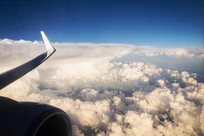 部分引擎和机翼在飞行与美丽的多云天空的背景，复制空间，旅行和数字游牧的概念