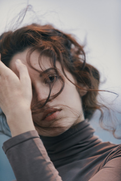 性感的年轻女子把她的头发从她的前额